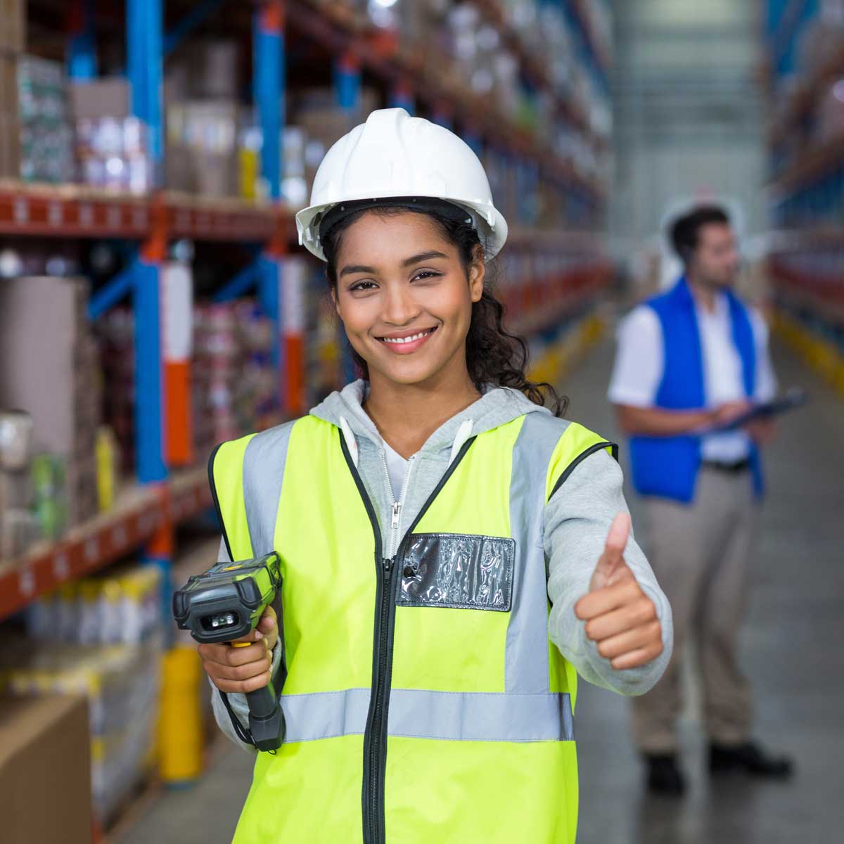 Female warehouse worker showing thumbs up sign